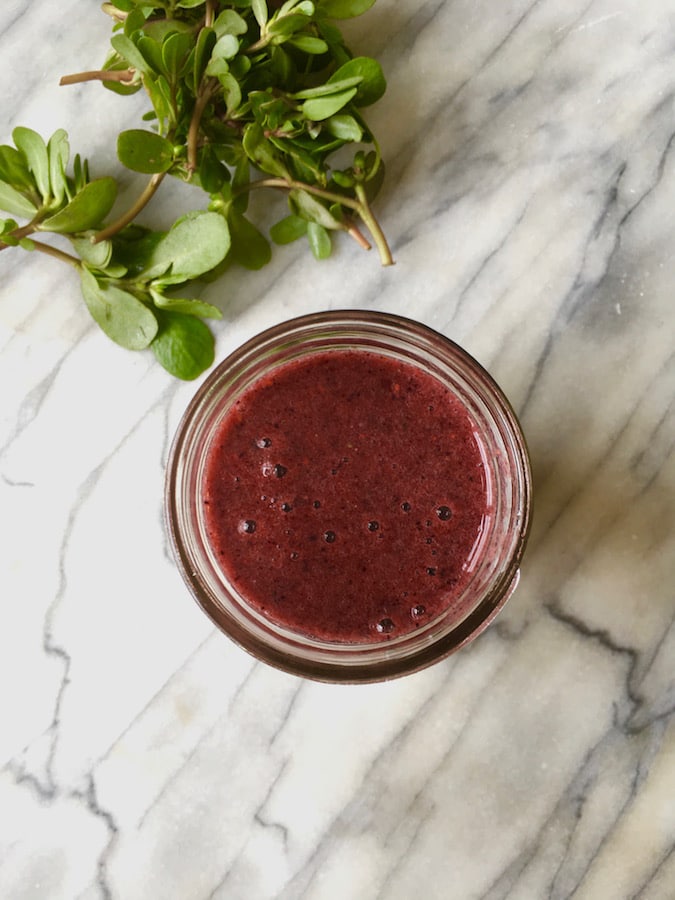 A glass full of purslane blueberry superfood smoothie