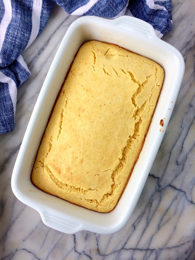 Overhead shot of a rectangular pan with an allergy friendly Top 8 free cornbread inside, on a marble countertop.